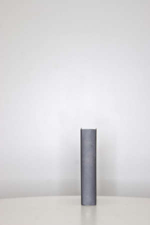 Large black book standing straight up on a wooden tableの写真素材