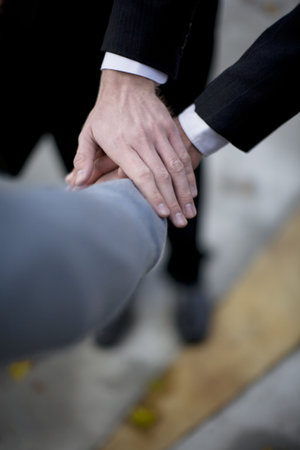 close up view of three peoples' hands on top of each other in business situation 