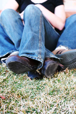 three quarter length shot of heterosexual couple sitting down on grass together の写真素材