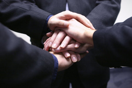 Business people with their hands together in teamwork