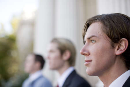 three business men standing and looking in same directionの写真素材