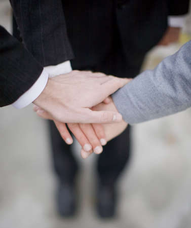 close-up of three businessmen's hands on top of each otherの写真素材