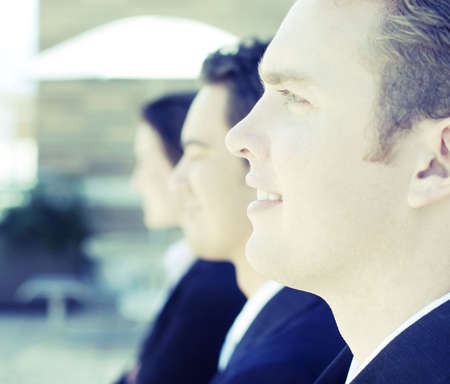 three business people standing in a row looking in same directionの写真素材