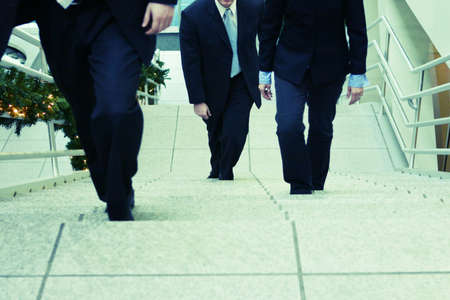 three business people walking up stepsの写真素材