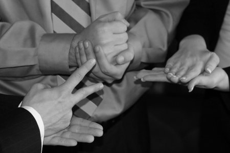 close-up on three businesspeopleâ€™s hands playing hands, rocks, scissors