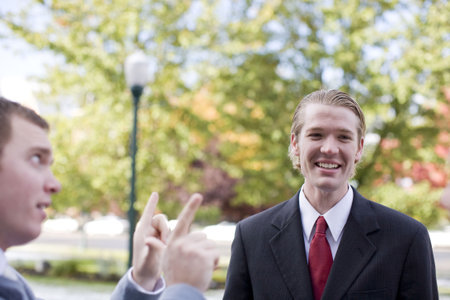 side view of businessman talking with another businessman who is laughing