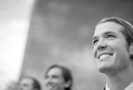 three business men standing and smiling in same directionの写真素材