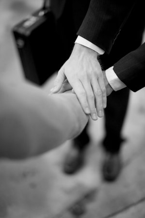 close-up of three businessmen's hands on top of each other