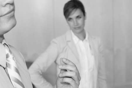 side view of  businessman rubbing his fingers with woman looking at himの写真素材