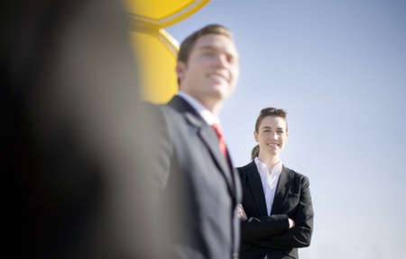 Over the shoulder view of business team outside with giant yellow object in backgroundの写真素材