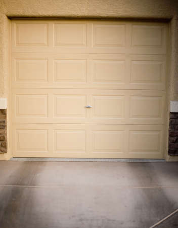 Closed tan garage door with tan building exteriorの写真素材