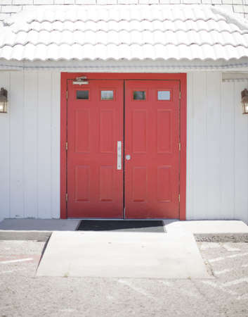 Red doors entrance with white building exteriorの写真素材