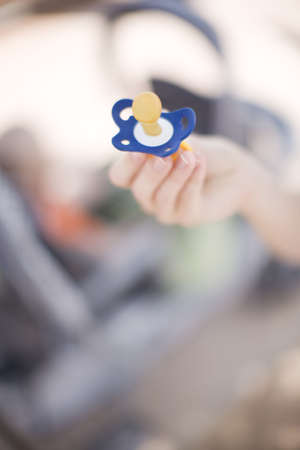 Single hand holding blue  binkyの写真素材