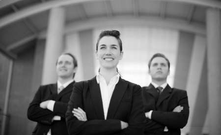 Successful businesspeople standing together looking in same direction with arms foldedの写真素材