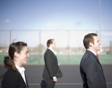 Business people standing in a row looking in same direction and smilingの写真素材