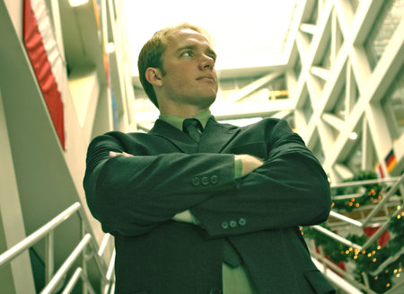 confident businessman standing with his arms folded in an office building