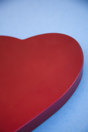 a close-up of a red heart shaped symbol on a blue background の写真素材