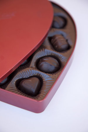 an open box of holiday chocolates with the box open so you can see some pieces of chocolate