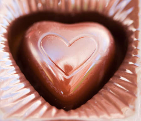 a close-up of a piece of chocolate with a heart shaped symbol stamped on the chocolate の写真素材