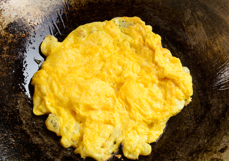 yellow omelette cooking on panの写真素材