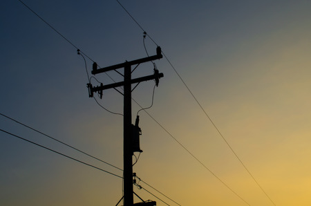 Electricity pole and lines at dusk.の写真素材