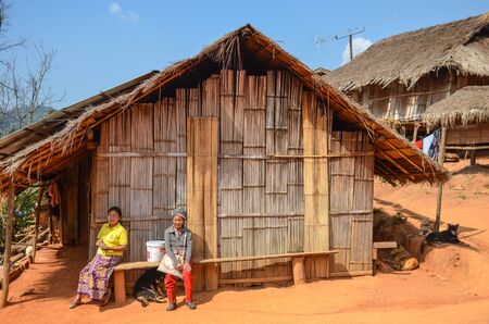 CHIANG RAI, THAILAND - JANUARY 29, 2014: tribal woman sitting in front of their home at Chiang Rai, Thailandのeditorial素材