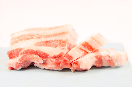 streaky pork on blue block on white backgroundの写真素材