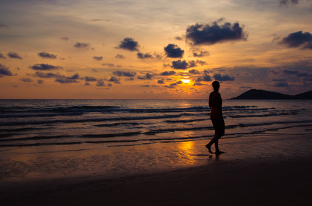 silhouette sunset with girl walking on beachの写真素材