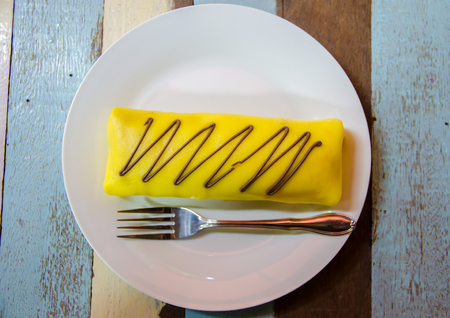 banana crape cake on white plate on wooden table on top viewの写真素材