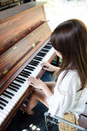 asian girl playing piano in verticalの写真素材
