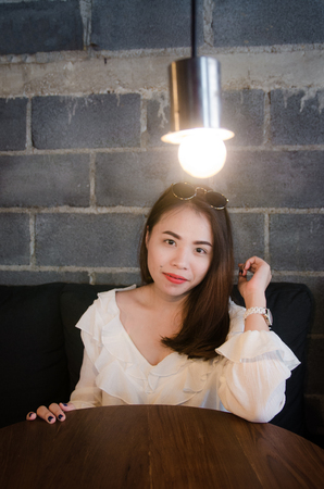 asian pretty girl sitting in cafe with happiness faceの写真素材