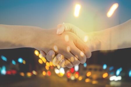 two man are hand shaking on blurred light backgroundの写真素材