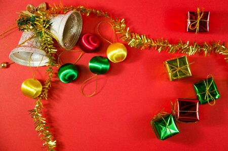 group of bell, ball and gift in christmas on red background on top viewの写真素材