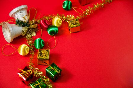 group of bell, ball and gift in christmas on red background on top viewの写真素材