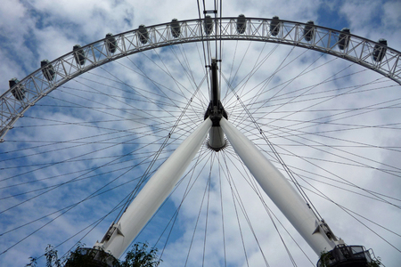 View of the London Eye/Millennium wheel from the base against a blue sky and fluffy white cloudsのeditorial素材