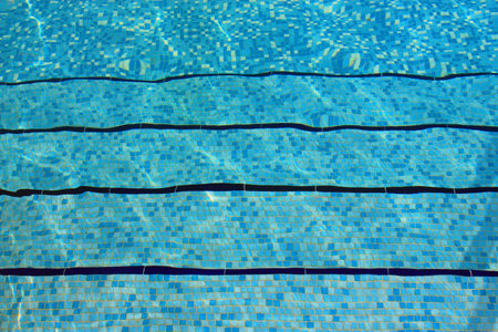 Underwater steps in a swimming pool with blue mosaic tilesの写真素材