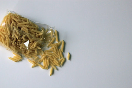 Isolated clear cellophane bag of gluten free penne pasta on a white background with copy space on the rightの写真素材