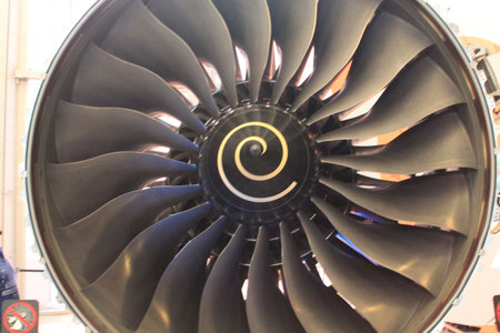 Close up of a plane engine with fan blades for sending air into the combustor