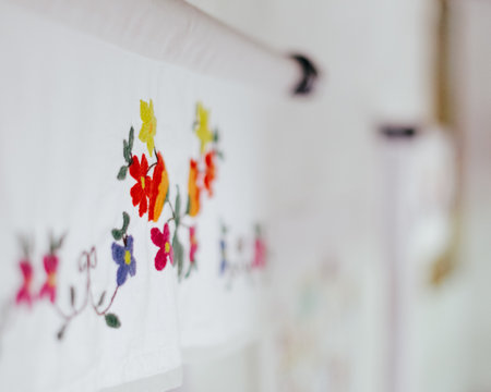 Colorful embroidery on a white wall. Selective focus.の写真素材