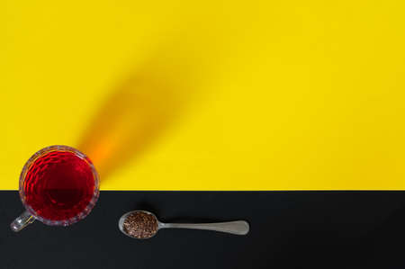 Red tea cup isolated on black and yellow backgroundの写真素材