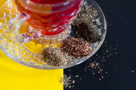 Red tea cup isolated on black and yellow backgroundの写真素材