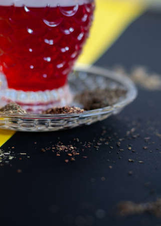 Red tea cup isolated on black and yellow backgroundの写真素材