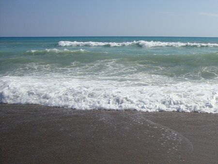 white foam from the sea on the sandの写真素材