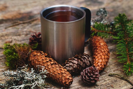 Still Life with Mug of Hot Tea on Rustic Wooden table with Forest elements - Winter morning concept - top view pointの写真素材
