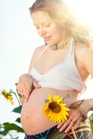 Pregnant Woman with Bodyart on her Belly and Handsの写真素材