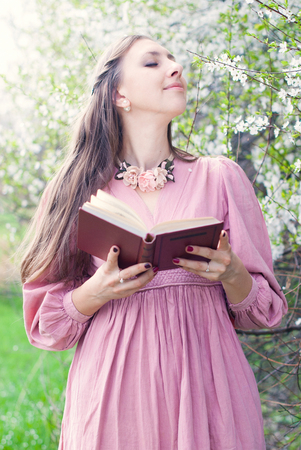 Romantic Portrait of Young Beautiful Woman in the Park with Spring Blossom trees - Beauty and Fashion Conceptの写真素材