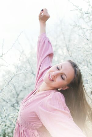 Romantic Portrait of Young Beautiful Woman in the Park with Spring Blossom trees - Beauty and Fashion Conceptの写真素材