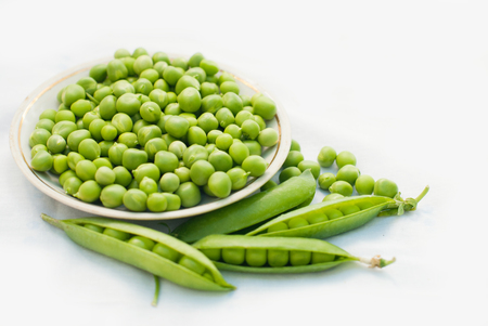 Green pea in a bowl of top view on white background with copy spaceの写真素材