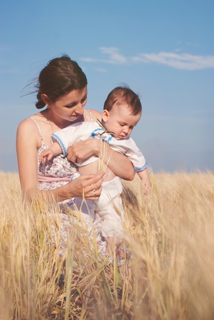 Happy Family outdoors - walking at the Summer wheat field - happy healthy child with motherの写真素材