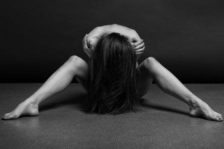 Beautiful body of young woman over dark backgroundの写真素材